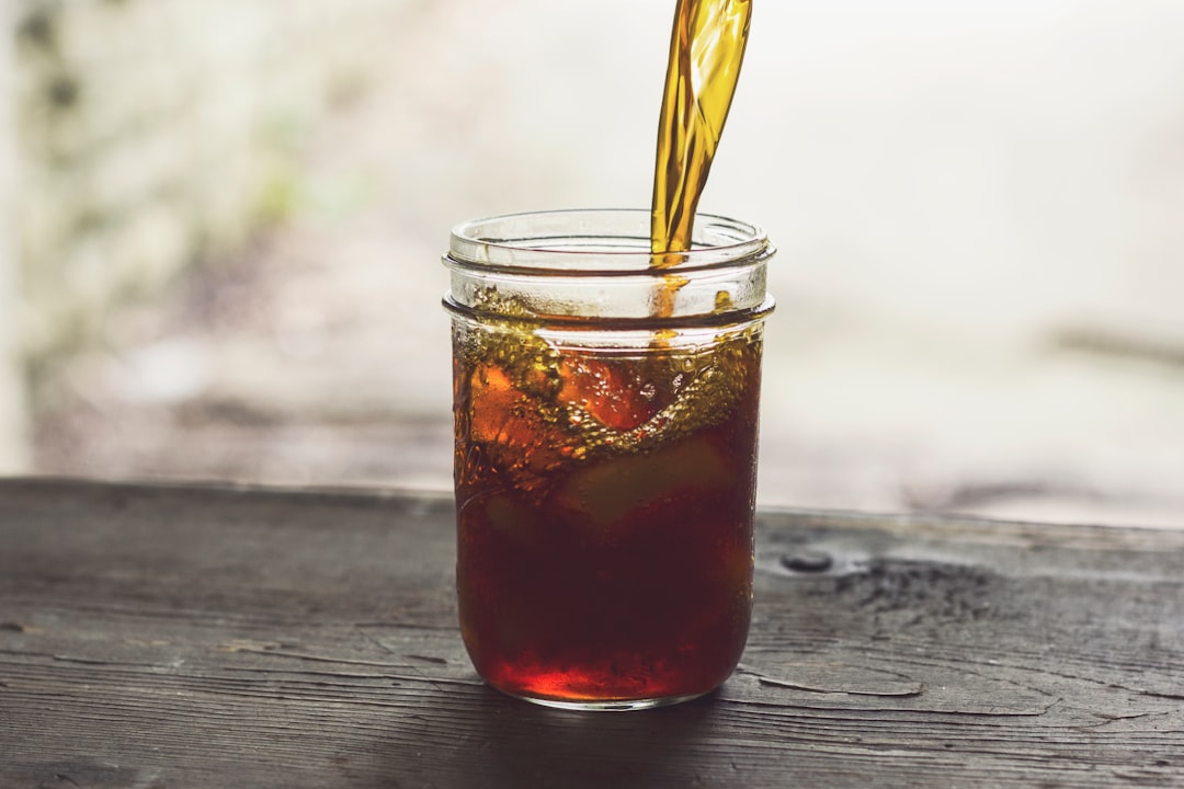 Iced tea being poured slowly into a glass jar over ice — a metaphor for taking smaller, steady withdrawals instead of one large, forced one.