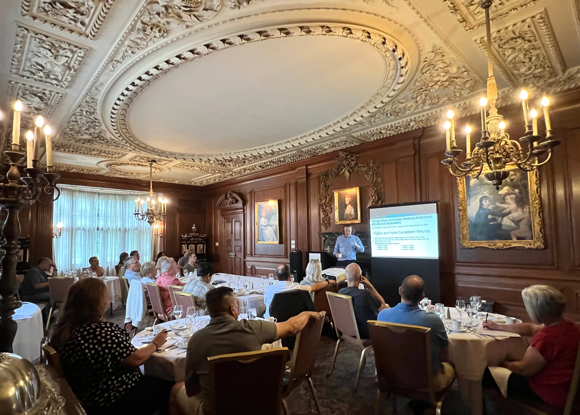 Attendees seated for a V8 Wealth seminar in an ornate historic dining room